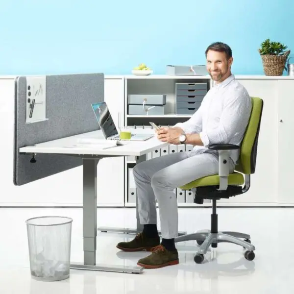 Mies työskentelee Economy Flex -sähköpöytä, suora malli toimistossa.