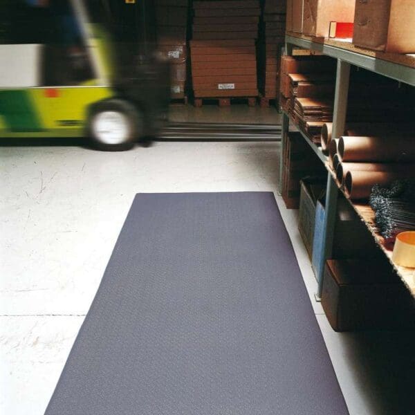 Harmaa Ergonominen matto Yoga Super varastossa rekka taustalla.