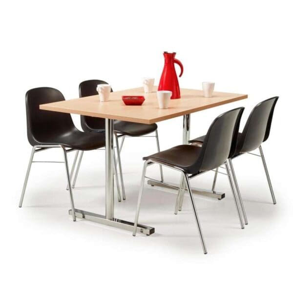 Ruokapöytä, jossa on neljä tuolia ja punainen maljakko.