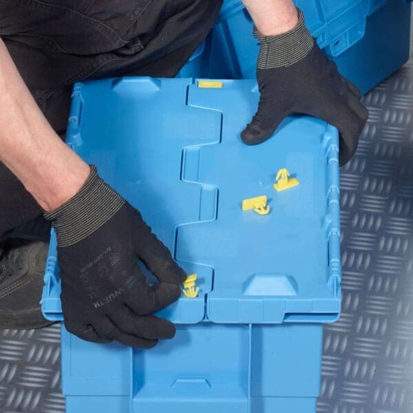 Mies pitelee sinistä säilytyslaatikkoa. Sinettejä 100 kpl Integra-laatikolle.