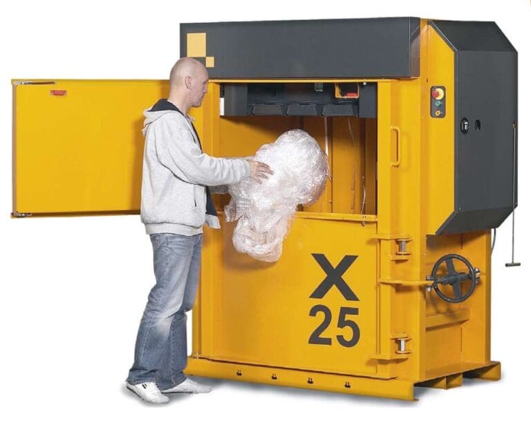 Mies lataa muovijätettä keltaiseen paalaimeen X25.