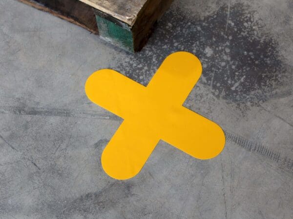 Keltainen Lattiaopaste merkintäteipit betonilattialla.