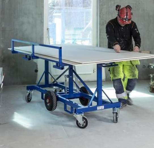 Worker using a heavy-duty tilting board trolley in the horizontal work position