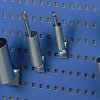 R24 pegboard tube holders storing tools vertically on a blue perforated panel
