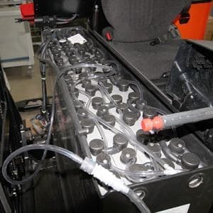 Lähikuva avoimen ajoneuvon moottorista, jossa näkyy sisäiset komponentit ja trukkiakut.